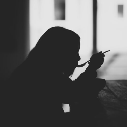 Mujer comiendo en la oscuridad